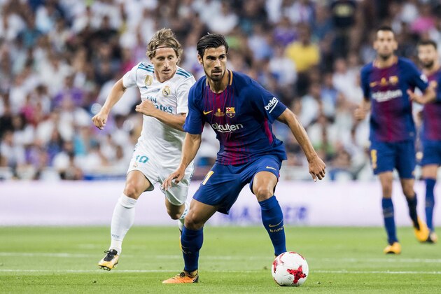 MADRID, SPAIN - AUGUST 16 - Andre Filipe Tavares Gomes (r) of FC Barcelona is followed by Luka Modric of Real Madrid during their Supercopa de Espana Final 2nd Leg match between Real Madrid and FC Barcelona at the Estadio Santiago Bernabeu on 16 August 2017 in Madrid, Spain. (Photo by Power Sport Images/Getty Images)