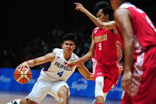 Sandy Febrianysah Kurniawan of Indonesia (R) attempts to block against Kiefer Ravena of the Philippines (L) during the men's basketball gold medal match at the 28th Southeast Asian Games (SEA Games) in Singapore on June 15, 2015. AFP PHOTO / MOHD FYROL        (Photo credit should read MOHD FYROL/AFP/Getty Images)