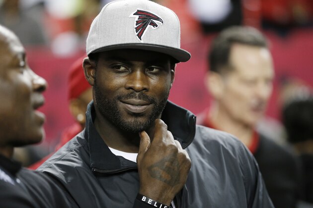 FILE - In this Jan. 1, 2017, file photo, former Atlanta Falcons quarterback Michael Vick stands on the sidelines before NFL football game between the Falcons and the New Orleans Saints in Atlanta. Vick never made it to the Super Bowl with the Falcons. And his career with the team ended in disgrace. Yet no one is rooting harder for the Falcons to win their first championship.(AP Photo/John Bazemore, File)
