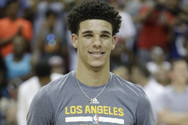 Los Angeles Lakers' Lonzo Ball holds up the trophy for the most valuable player in the NBA summer league, before the team's basketball game against the Portland Trail Blazers, Monday, July 17, 2017, in Las Vegas. (AP Photo/John Locher)