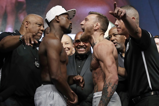 Floyd Mayweather Jr., center left, and Conor McGregor face off during a weigh-in Friday, Aug. 25, 2017, in Las Vegas. The two are scheduled to fight in a boxing match Saturday in Las Vegas. (AP Photo/John Locher)