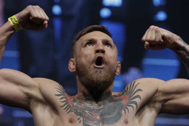 Conor McGregor poses on the scale during a weigh-in Friday, Aug. 25, 2017, in Las Vegas for his Saturday boxing bout against Floyd Mayweather Jr. (AP Photo/John Locher)
