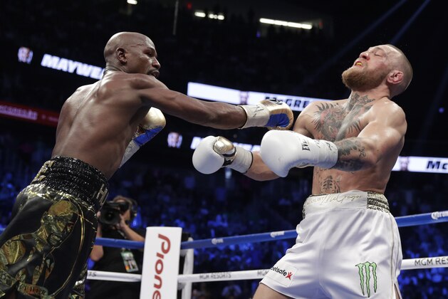 El estadounidense Floyd Mayweather Jr. golpea al irlandés Conor McGregor durante su pelea del sábado 26 de agosto de 2017 en Las Vegas (AP Foto/Isaac Brekken)