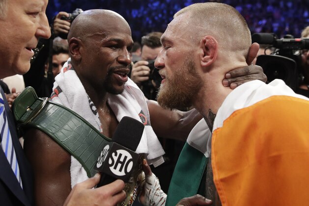 Floyd Mayweather Jr., left, embraces Conor McGregor after a super welterweight boxing match Saturday, Aug. 26, 2017, in Las Vegas. (AP Photo/Isaac Brekken)