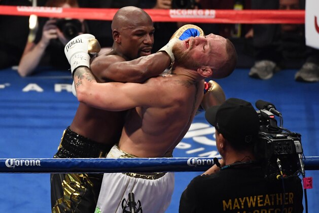 LAS VEGAS, NV - AUGUST 26:  (L-R) Floyd Mayweather Jr. throws a punch at Conor McGregor during their super welterweight boxing match on August 26, 2017 at T-Mobile Arena in Las Vegas, Nevada.  (Photo by Ethan Miller/Getty Images)