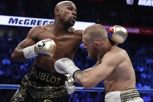 Floyd Mayweather Jr., left, fights Conor McGregor in a super welterweight boxing match Saturday, Aug. 26, 2017, in Las Vegas. (AP Photo/Isaac Brekken)