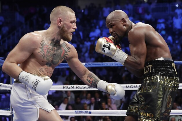 Floyd Mayweather Jr., right, fights Conor McGregor in a super welterweight boxing match Saturday, Aug. 26, 2017, in Las Vegas. (AP Photo/Isaac Brekken)