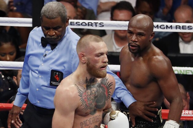 Referee Robert Byrd, left, gets between Floyd Mayweather Jr., right, and Conor McGregor in a super welterweight boxing match Saturday, Aug. 26, 2017, in Las Vegas. (AP Photo/Eric Jamison)
