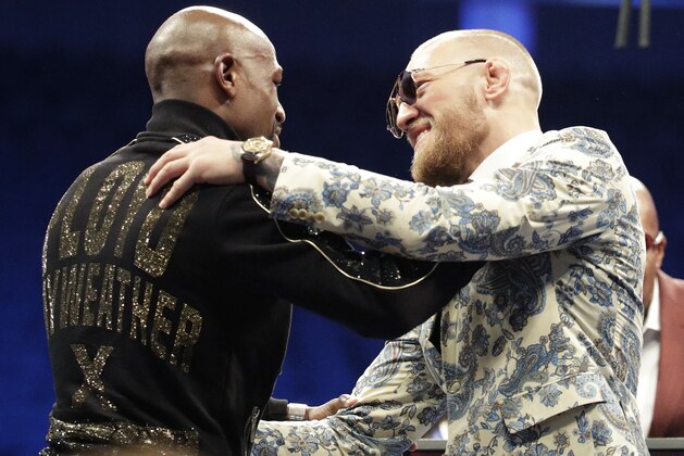 Floyd Mayweather Jr., left, and Conor McGregor embrace during a news conference after a super welterweight boxing match Sunday, Aug. 27, 2017, in Las Vegas. (AP Photo/Isaac Brekken)