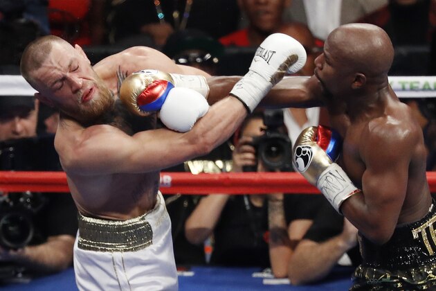 Floyd Mayweather Jr. hits Conor McGregor in a super welterweight boxing match Saturday, Aug. 26, 2017, in Las Vegas. (AP Photo/Eric Jamison)