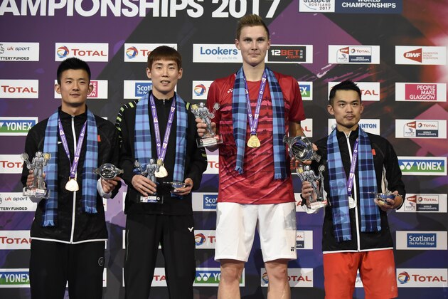 Bronze medalists, China's Chen Long (L) and South Korea's Son Wan Ho (2nd L), gold medalist Denmark's Viktor Axelsen, silver China's Lin Dan (R) celebrate on the podium after the men's singles during the 2017 BWF World Championships of badminton at Emirates Arena in Glasgow on August 27, 2017. / AFP PHOTO / ANDY BUCHANAN        (Photo credit should read ANDY BUCHANAN/AFP/Getty Images)