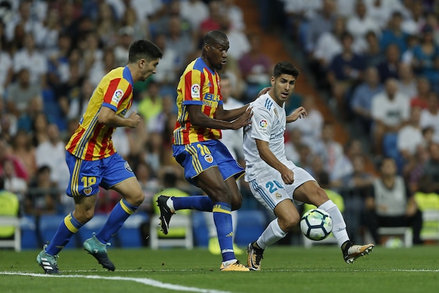 Real Madrid's Marco Asensio, right, vies for the ball with Valencia's Carlos Soler, left, and Antonio Latorre Grueso during a Spanish La Liga soccer match between Real Madrid and Valencia at the Santiago Bernabeu stadium in Madrid, Sunday, Aug. 27, 2017. (AP Photo/Francisco Seco)