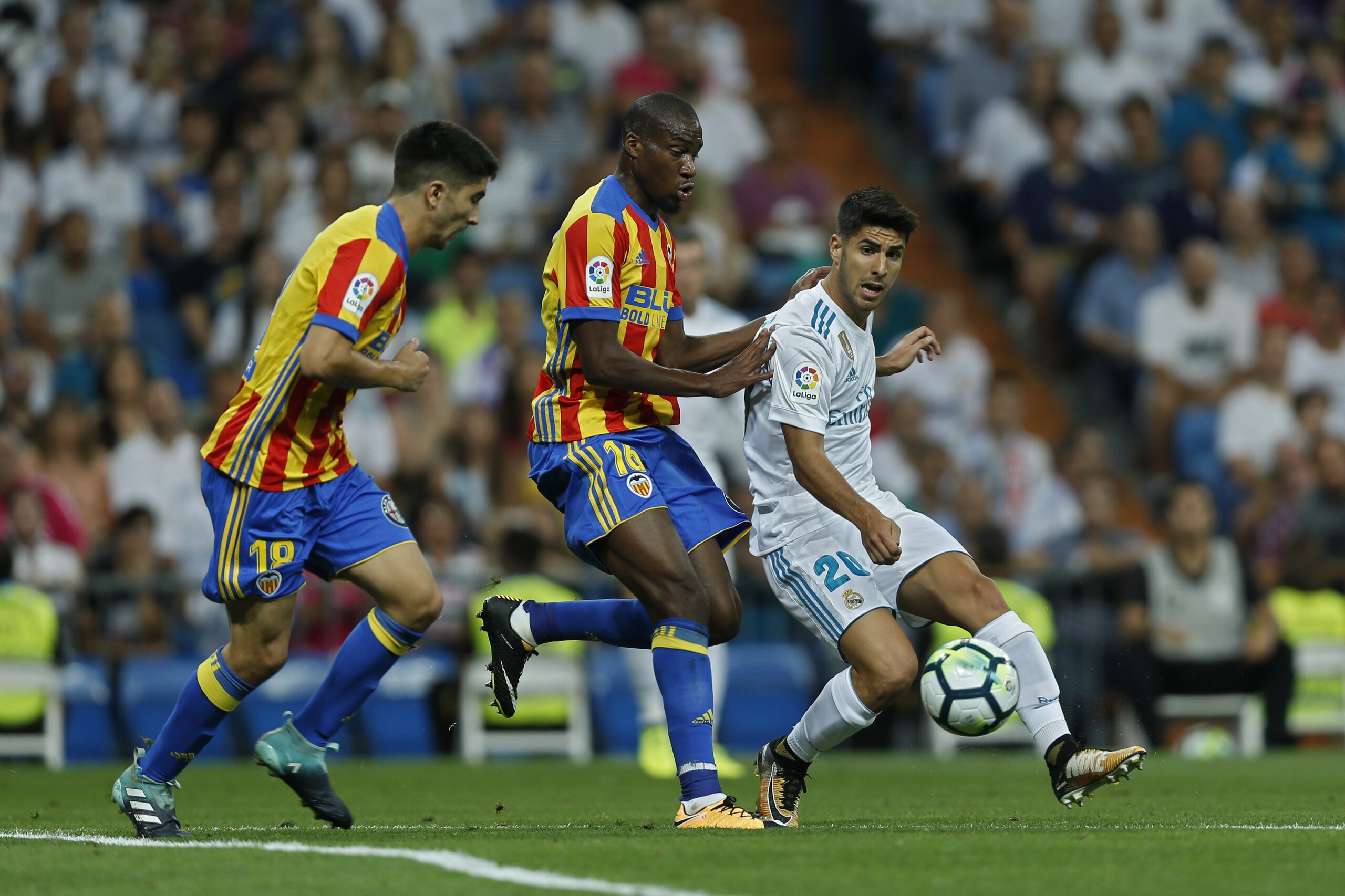 Real Madrid's Marco Asensio, right, vies for the ball with Valencia's Carlos Soler, left, and Antonio Latorre Grueso during a Spanish La Liga soccer match between Real Madrid and Valencia at the Santiago Bernabeu stadium in Madrid, Sunday, Aug. 27, 2017. (AP Photo/Francisco Seco)
