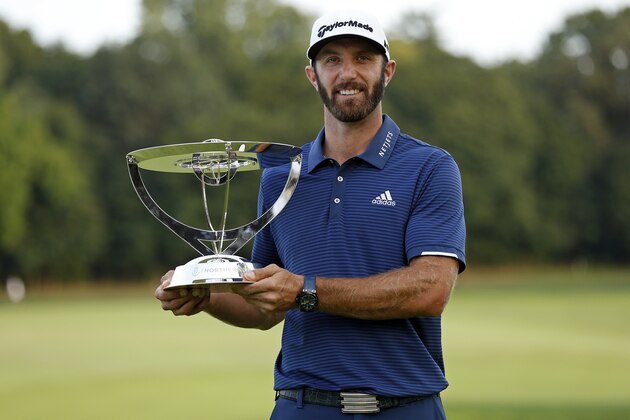 Dustin Johnson holds up his trophy after winning The Northern Trust golf tournament over Jordan Spieth in a playoff on Sunday, Aug. 27, 2017, in Old Westbury, N.Y. (AP Photo/Adam Hunger)