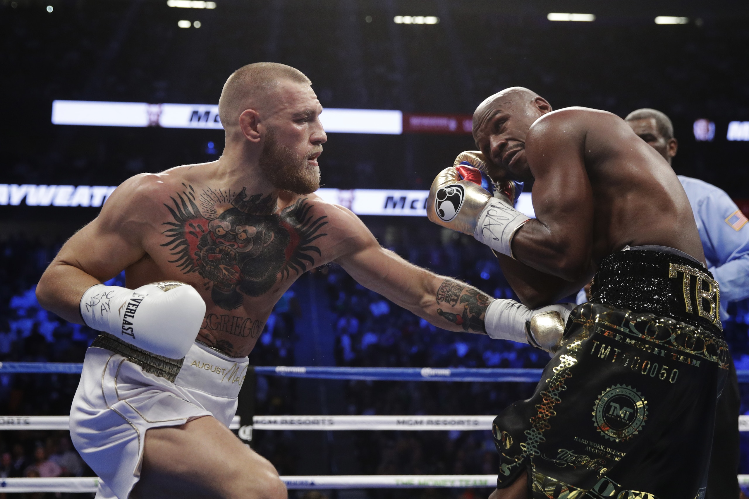 Conor McGregor, left, fights Floyd Mayweather Jr. in a super welterweight boxing match Saturday, Aug. 26, 2017, in Las Vegas. (AP Photo/Isaac Brekken)