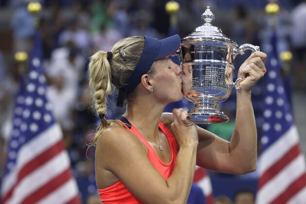 Angelique Kerber, of Germany, kisses the championship trophy after beating Karolina Pliskova, of the Czech Republic, to win the women's singles final of the U.S. Open tennis tournament, Saturday, Sept. 10, 2016, in New York. (AP Photo/Darron Cummings)