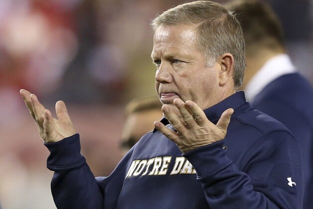 FILE - In this Oct. 31, 2015, file photo, Notre Dame head coach Brian Kelly gestures to his players as they warm up before an NCAA college football game against Temple, in Philadelphia. Kelly apologized to his players in the locker room after the loss at North Carolina State that he couldn’t find a way to win. “I’ve got to look hard at how I’m doing it to figure out a way to get a win for you guys, because you deserve it,” he said. (AP Photo/Mel Evans, File)