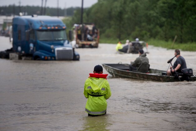 People make their way through a flooded street during the aftermath of Hurricane Harvey on August 29, 2017 in Houston, Texas.
Floodwaters have breached a levee south of the city of Houston, officials said Tuesday, urging residents to leave the area immediately. / AFP PHOTO / Brendan Smialowski        (Photo credit should read BRENDAN SMIALOWSKI/AFP/Getty Images)