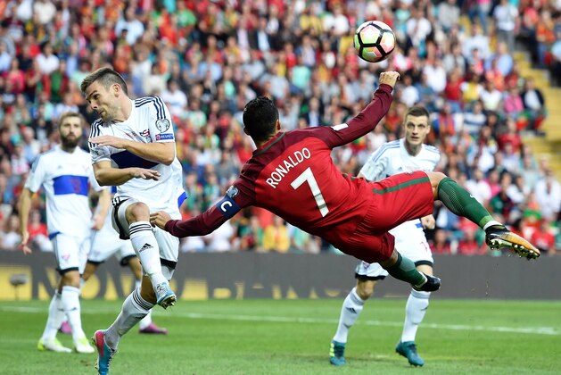 Portugal's forward Cristiano Ronaldo (C) kicks the ball to score the opening goal during the WC2018 qualifying football match Portugal vs Faroe Islands at the Bessa stadium in Porto on August 31, 2017. / AFP PHOTO / FRANCISCO LEONG        (Photo credit should read FRANCISCO LEONG/AFP/Getty Images)