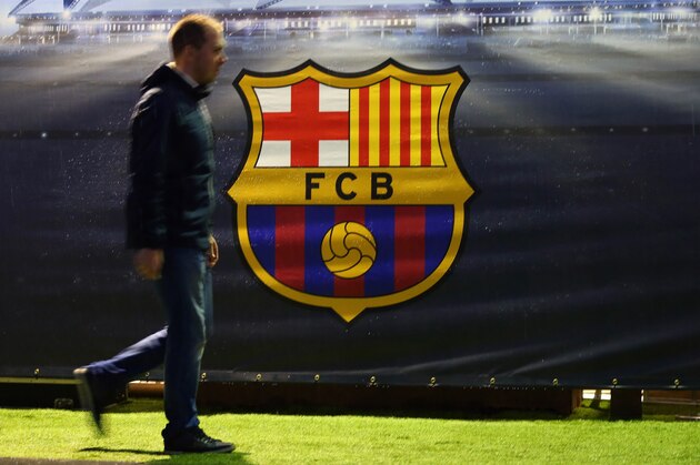 BARCELONA, SPAIN - MARCH 16:  A fan walks past the FC Barcelona club badge before the UEFA Champions League match between FC Barcelona and Arsenal at Camp Nou on March 16, 2016 in Barcelona, Spain.  (Photo by Catherine Ivill - AMA/Getty Images)
