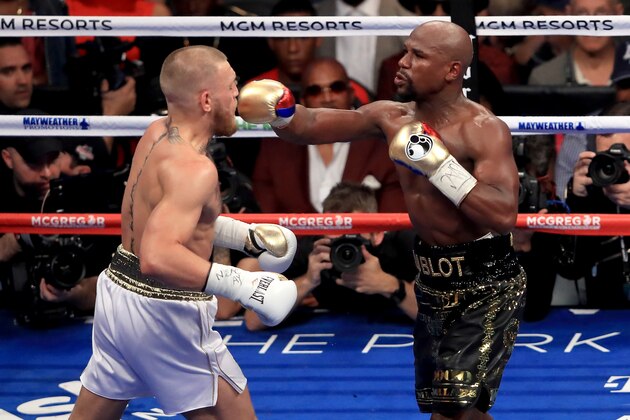 LAS VEGAS, NV - AUGUST 26:  (R-L) Floyd Mayweather Jr. throws a punch at Conor McGregor during their super welterweight boxing match on August 26, 2017 at T-Mobile Arena in Las Vegas, Nevada.  (Photo by Sean M. Haffey/Getty Images)
