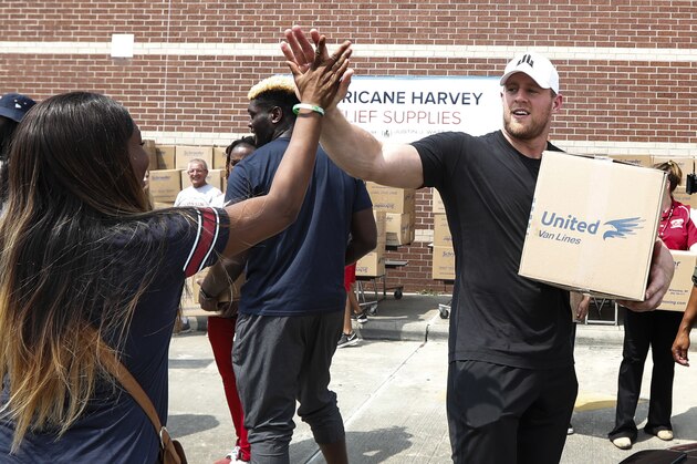 HOUSTON, TX - SEPTEMBER 3: (AFP OUT) Anna Ucheomumu high fives Houston Texans defensive end J.J. Watt after loading a car with relief supplies for people impacted by Hurricane Harvey on September 3, 2017, in Houston, Texas. J.J. Watt's Hurricane Harvey Relief Fund has raised more than $18 million to date to help those affected by the storm. (Photo by Brett Coomer - Pool/Getty Images)