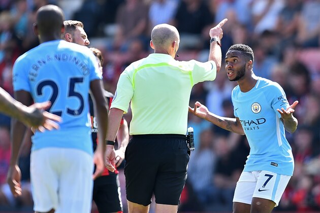 Manchester City's English midfielder Raheem Sterling (R) gestures to English referee Mike Dean after he receives a second yellow card for going into the crowd in celebrating his goal during the English Premier League football match between Bournemouth and Manchester City at the Vitality Stadium in Bournemouth, southern England on August 26, 2017.
Manchester City won the game 2-1. / AFP PHOTO / Glyn KIRK / RESTRICTED TO EDITORIAL USE. No use with unauthorized audio, video, data, fixture lists, club/league logos or 'live' services. Online in-match use limited to 75 images, no video emulation. No use in betting, games or single club/league/player publications.  /         (Photo credit should read GLYN KIRK/AFP/Getty Images)