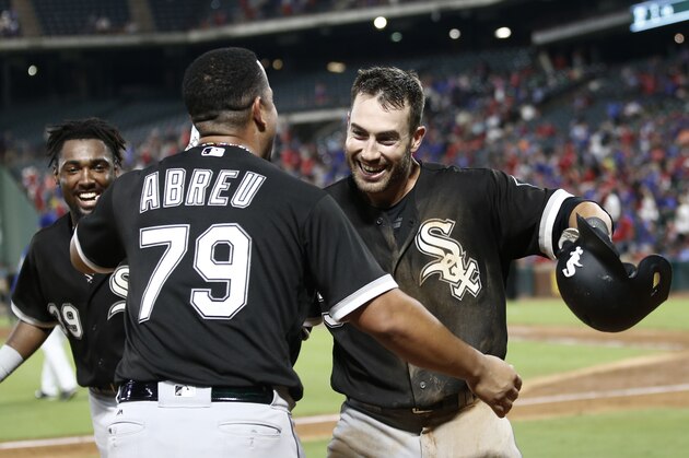 Nicky Delmonico (30) es felicitado por el cubano José Abreu, su compañero en los Medias Blancas de Chicago, luego de conectar un jonrón dentro del parque ante los Rangers de Texas, el viernes 18 de agosto de 2017  (AP Foto/Mike Stone)