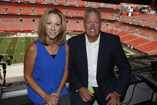 ESPN broadcasters Beth Mowins, left, and Rex Ryan pose in the booth before an NFL football game between the New York Giants and the Cleveland Browns, Monday, Aug. 21, 2017, in Cleveland. (AP Photo/Ron Schwane)