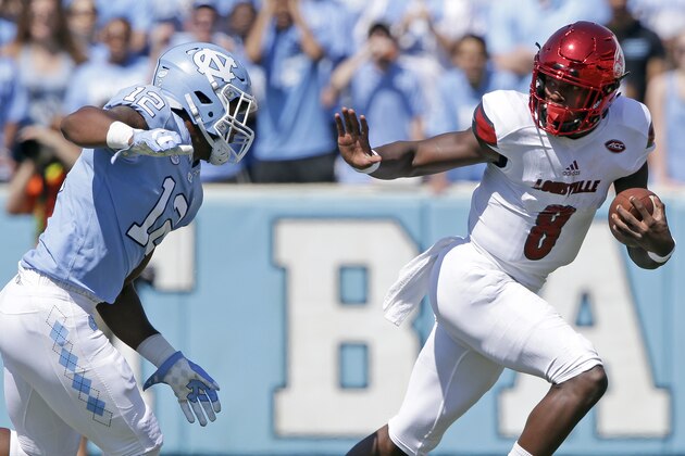 Louisville quarterback Lamar Jackson (8) runs the ball as North Carolina's Tomon Fox (12) chases during the first half of an NCAA college football game in Chapel Hill, N.C., Saturday, Sept. 9, 2017. (AP Photo/Gerry Broome)