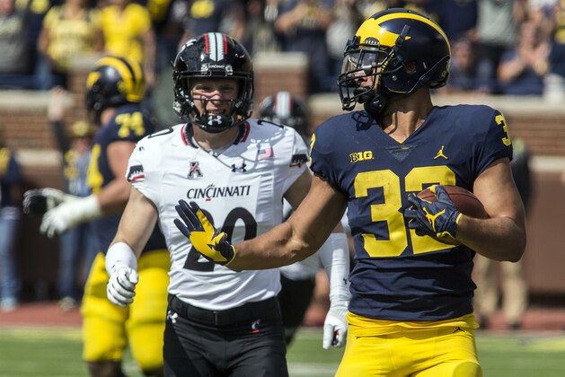 Michigan running back Ty Isaac (32) rushes ahead of Cincinnati safety Carter Jacobs (20) in the fourth quarter of an NCAA college football game in Ann Arbor, Mich., Saturday, Sept. 9, 2017. Michigan won 36-14. (AP Photo/Tony Ding)