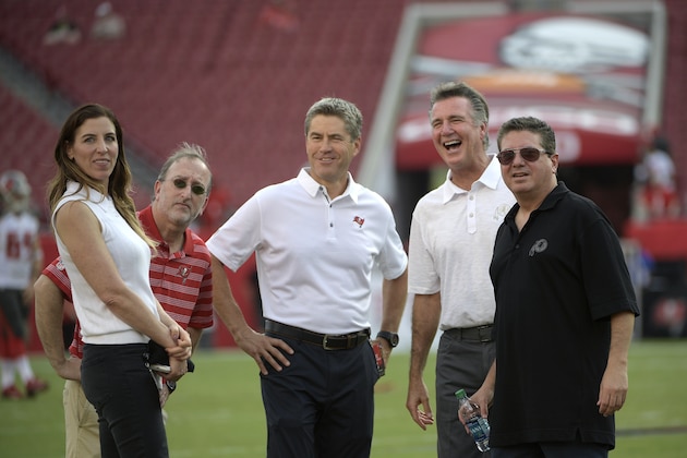 Washington Redskins owner Daniel Snyder, right, and team president Bruce Allen, second from right, talk with Tampa Bay Buccaneers co-chairman Edward Glazer, second from left, Glazer Family Foundation co-president Darcie Glazer Kassewitz, left, and Joel Kassewitz chat on the field before an NFL preseason football game Thursday, Aug. 31, 2017, in Tampa, Fla. (AP Photo/Phelan M. Ebenhack)