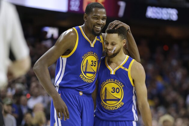 FILE - In this Friday, June 9, 2017, file photo, Golden State Warriors' Kevin Durant (35) hugs teammate Stephen Curry (30) during the first half of Game 4 of basketball's NBA Finals against the Cleveland Cavaliers, in Cleveland. The 2017 NBA Champion Golden State Warriors re-signed free agents Stephen Curry, Kevin Durant, Andre Iguodala, Shaun Livingston, Zaza Pachulia and David West to contracts, the team announced Tuesday, July 25, 2017. (AP Photo/Tony Dejak, File)