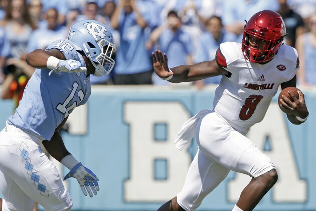 FILE - In this Sept. 9, 2017, file photo, Louisville quarterback Lamar Jackson (8) runs the ball as North Carolina's Tomon Fox (12) chases him during the first half of an NCAA college football game, in Chapel Hill, N.C. Jackson, the Heisman Trophy winner and All-American, leads the nation in total offense at 505 yards per game heading into a showdown with No. 3 Clemson. (AP Photo/Gerry Broome, File)