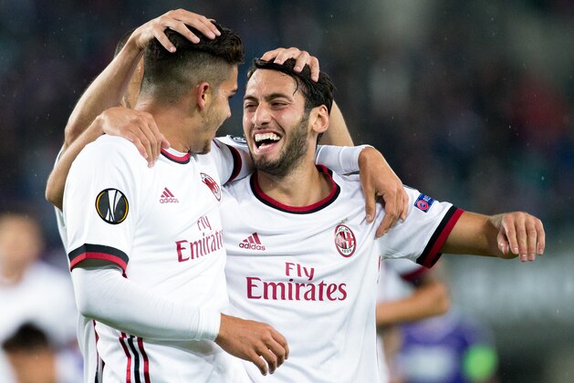 AC Milan's forward from Portugal Andre Silva (L) celebrates scoring with midfielder from Turkey Hakan Calhanoglu during the UEFA Europa League group D football match FK Austria Wien v AC Milan in Vienna, Austria on September 14, 2017.  / AFP PHOTO / APA / GEORG HOCHMUTH / Austria OUT        (Photo credit should read GEORG HOCHMUTH/AFP/Getty Images)