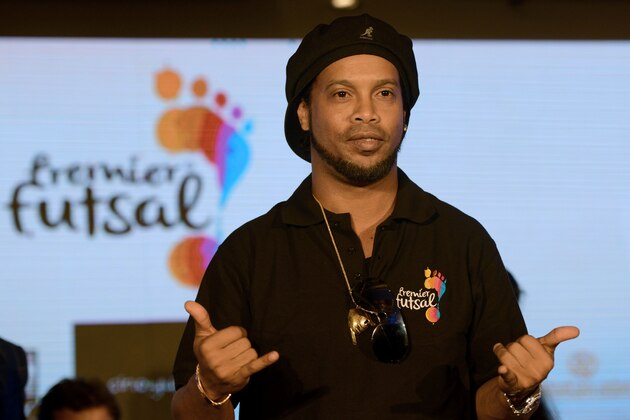 Former Brazilian professional footballer Ronaldinho gestures during a news conference to announce the second season of the Premier Futsal Football League 2017 in the Indian city of Mumbai on July 14, 2017. 
 / AFP PHOTO / PUNIT PARANJPE        (Photo credit should read PUNIT PARANJPE/AFP/Getty Images)