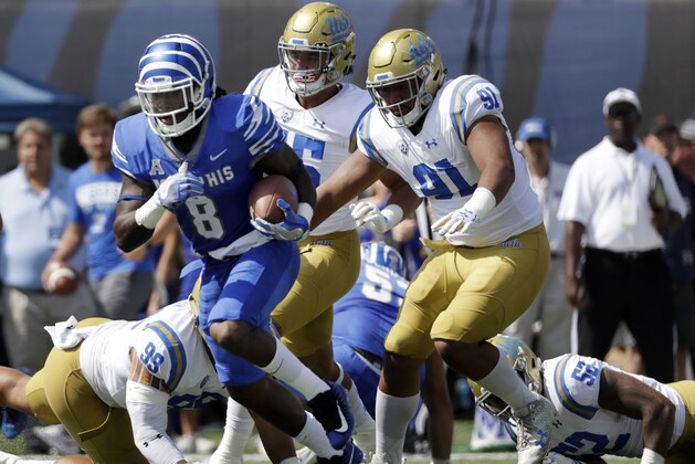 Memphis running back Darrell Henderson (8) gets past UCLA defenders Matt Dickerson (99) and Jacob Tuioti-Mariner (91) as Henderson runs for an 80-yard gain in the first half of an NCAA college football game Saturday, Sept. 16, 2017, in Memphis, Tenn. (AP Photo/Mark Humphrey)