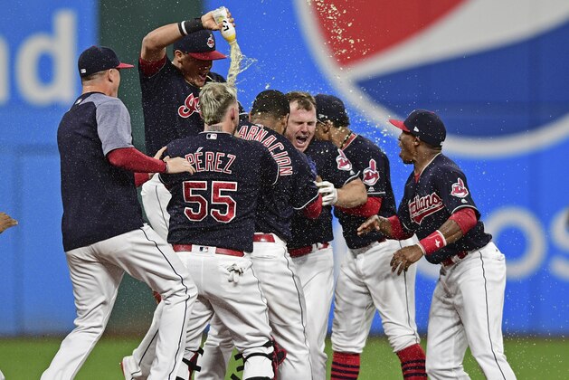 Cleveland Indians' Jay Bruce, center, celebrates with teammates after Bruce drove in the winning run with a double off Kansas City Royals relief pitcher Brandon Maurer during the 10th inning of a baseball game, Thursday, Sept. 14, 2017, in Cleveland. The Indians won 3-2. (AP Photo/David Dermer)