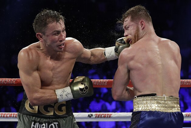 Gennady Golovkin, left, connects with a left to Canelo Alvarez during a middleweight title fight Sunday, Sept. 17, 2017, in Las Vegas. (AP Photo/John Locher)
