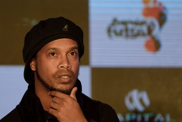 Former Brazilian professional footballer Ronaldinho gestures during a news conference to announce the second season of the Premier Futsal Football League 2017 in the Indian city of Mumbai on July 14, 2017.  / AFP PHOTO / PUNIT PARANJPE        (Photo credit should read PUNIT PARANJPE/AFP/Getty Images)