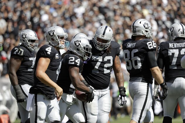 Oakland Raiders running back Marshawn Lynch (24) is congratulated by quarterback Derek Carr (4) and tackle Donald Penn (72) after scoring a touchdown against the New York Jets during the first half of an NFL football game in Oakland, Calif., Sunday, Sept. 17, 2017. (AP Photo/Marcio Jose Sanchez)