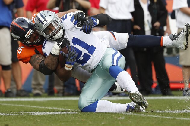 Dallas Cowboys running back Ezekiel Elliott (21) is tackled by Denver Broncos cornerback Chris Harris during the second half of an NFL football game, Sunday, Sept. 17, 2017, in Denver. (AP Photo/Jack Dempsey)