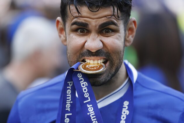 Chelsea's Diego Costa bites his winner's medal after they won the league, following the English Premier League soccer match between Chelsea and Sunderland at Stamford Bridge stadium in London, Sunday, May 21, 2017. (AP Photo/Frank Augstein)