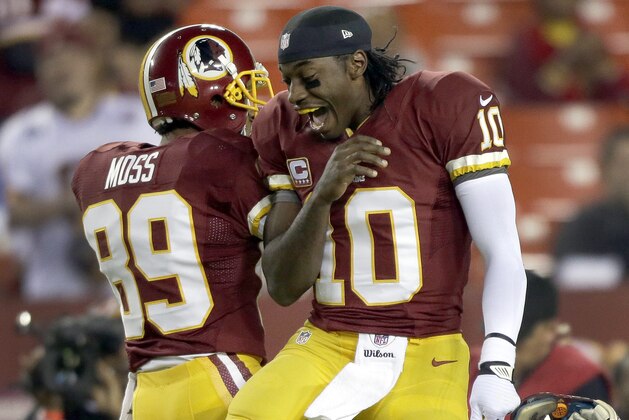 Washington Redskins wide receiver Santana Moss and quarterback Robert Griffin III jump into to each other before an NFL football game against the New York Giants in Landover, Md., Monday, Dec. 3, 2012. (AP Photo/Evan Vucci)
