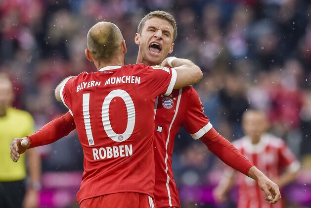Bayern Munich's German striker Thomas Mueller (R) celebrates scoring the opening goal with Bayern Munich's Dutch midfielder Arjen Robben during the German First division Bundesliga football match FC Bayern Munich v Mainz 05 in Munich, southern Germany, on September 16, 2017. / AFP PHOTO / Guenter SCHIFFMANN / RESTRICTIONS: DURING MATCH TIME: DFL RULES TO LIMIT THE ONLINE USAGE TO 15 PICTURES PER MATCH AND FORBID IMAGE SEQUENCES TO SIMULATE VIDEO. == RESTRICTED TO EDITORIAL USE == FOR FURTHER QUERIES PLEASE CONTACT DFL DIRECTLY AT + 49 69 650050
 / RESTRICTIONS: DURING MATCH TIME: DFL RULES TO LIMIT THE ONLINE USAGE TO 15 PICTURES PER MATCH AND FORBID IMAGE SEQUENCES TO SIMULATE VIDEO. == RESTRICTED TO EDITORIAL USE == FOR FURTHER QUERIES PLEASE CONTACT DFL DIRECTLY AT + 49 69 650050        (Photo credit should read GUENTER SCHIFFMANN/AFP/Getty Images)