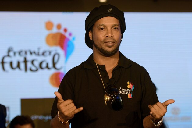 Former Brazilian professional footballer Ronaldinho gestures during a news conference to announce the second season of the Premier Futsal Football League 2017 in the Indian city of Mumbai on July 14, 2017. 
 / AFP PHOTO / PUNIT PARANJPE        (Photo credit should read PUNIT PARANJPE/AFP/Getty Images)