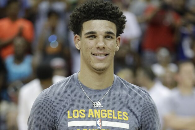 Los Angeles Lakers' Lonzo Ball holds up the trophy for the most valuable player in the NBA summer league, before the team's basketball game against the Portland Trail Blazers, Monday, July 17, 2017, in Las Vegas. (AP Photo/John Locher)