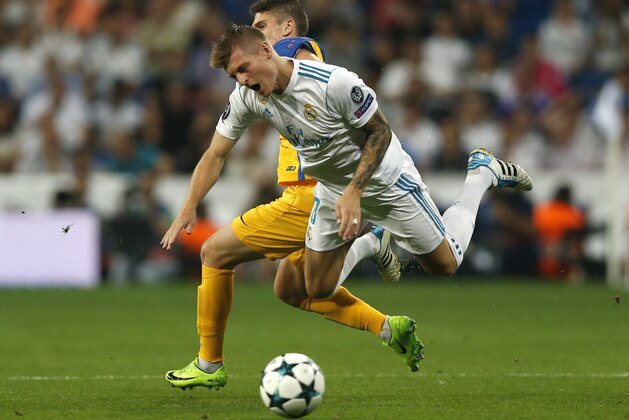 Real Madrid's Toni Kroos falls next to APOEL Nicosia's Roland Sallai during a Champions League group H soccer match between Real Madrid and Apoel Nicosia at the Santiago Bernabeu stadium in Madrid, Spain, Wednesday, Sept. 13, 2017. (AP Photo/Francisco Seco)