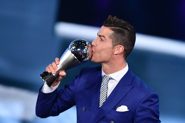 TOPSHOT - Real Madrid and Portugal's forward Cristiano Ronaldo kisses his trophy after winning the The Best FIFA Mens Player of 2016 Award next to FIFA president Gianni Infantino during The Best FIFA Football Awards ceremony, on January 9, 2017 in Zurich. / AFP / Fabrice COFFRINI        (Photo credit should read FABRICE COFFRINI/AFP/Getty Images)