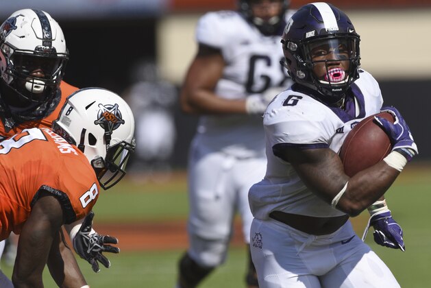 TCU running back Darius Anderson, right, break away from Oklahoma State defensive end Tralund Webber, left, and safety Za'Carrius Green to score a touchdown during the first half of an NCAA college football game in Stillwater, Okla., Saturday, Sept. 23, 2017.(AP Photo/Brody Schmidt)